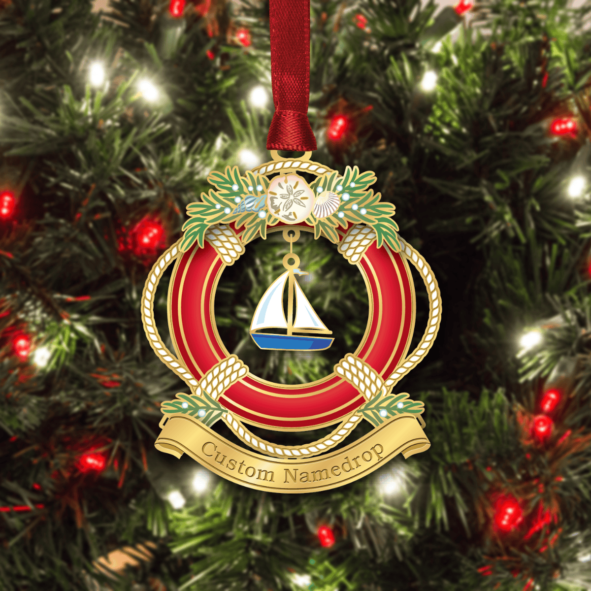 Custom namedrop ornament featuring a nautical life preserver decorated with evergreen branches, shells, and a sailboat centerpiece, displayed on a decorated Christmas tree