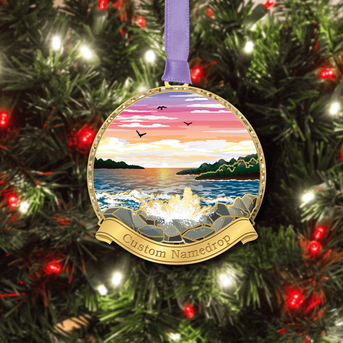 Custom namedrop ornament featuring a coastal sunset with ocean waves crashing against a rocky shoreline and distant islands, displayed on a decorated Christmas tree
