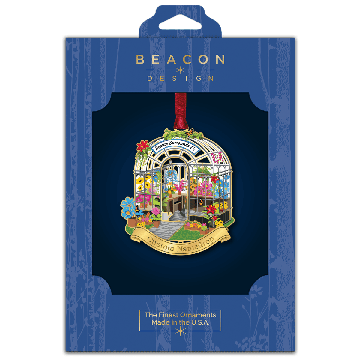 Custom namedrop ornament featuring a detailed greenhouse filled with colorful flowers and plants with the phrase “Beauty Surrounds Us,” displayed in Beacon Design retail packaging
