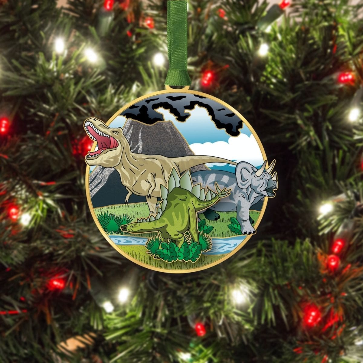 Dinosaurs ornament from Beacon Design hanging on a Christmas tree, featuring a T‑rex, triceratops, and stegosaurus in a prehistoric scene.